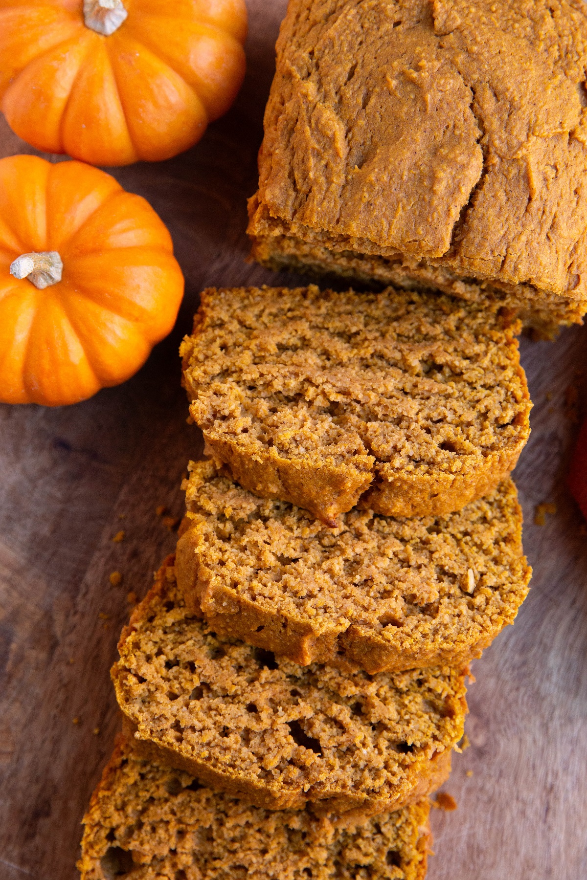 Pumpkin loaf on a cutting board cut into slices.