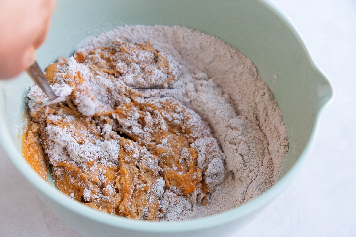 Mixing up the ingredients for pumpkin bread in a mixing bowl.