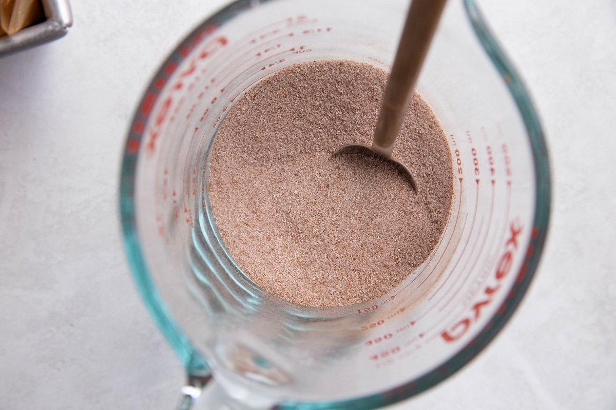 Cinnamon and sugar mixture in a measuring cup for the cinnamon swirl layer.