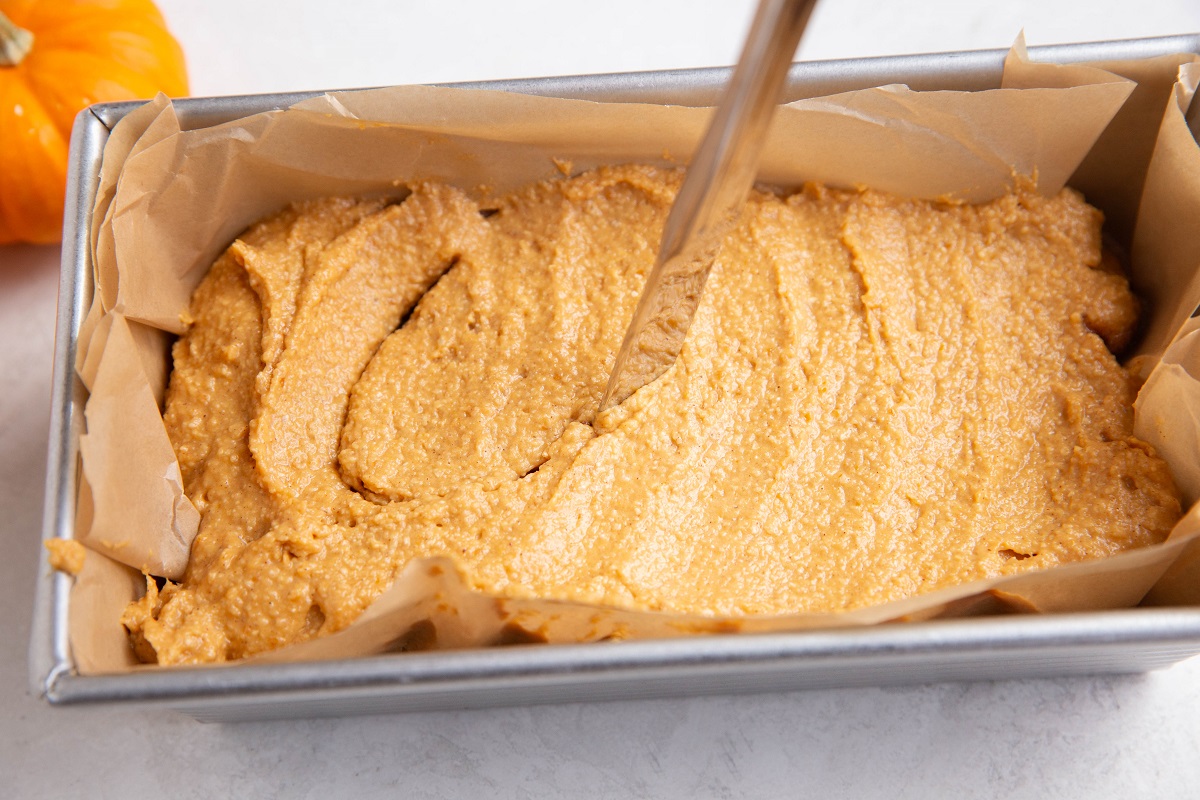 Knife cutting an "S" shape into the bread batter to make the cinnamon swirl.