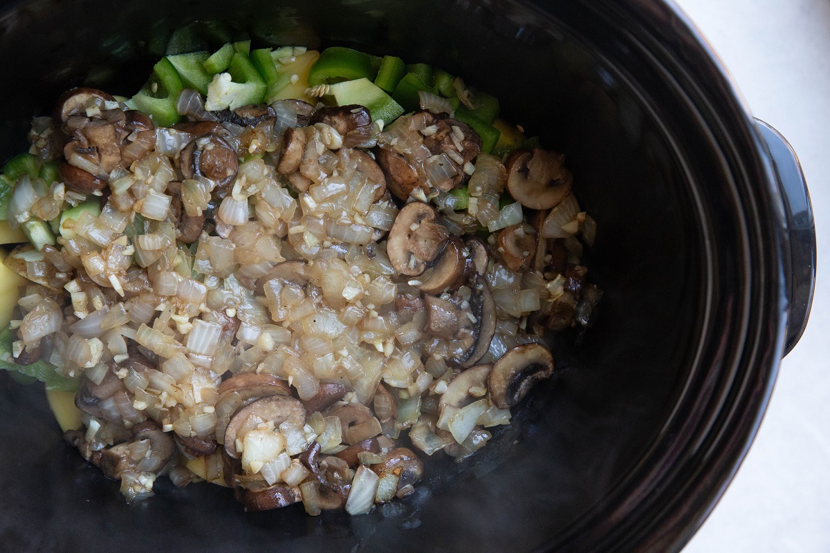 Potatoes, bell pepper, caramelized onion and mushrooms in a crock pot.