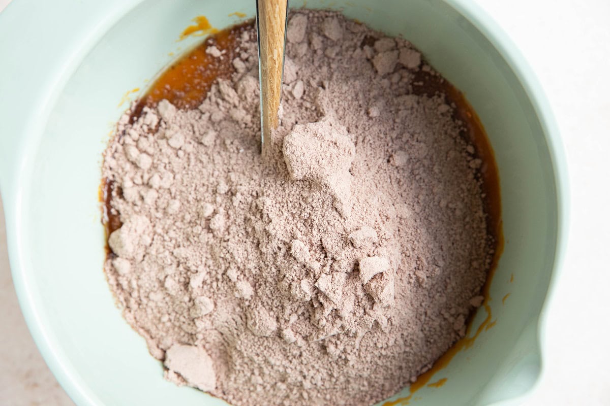 Wet ingredients in a large bowl with dry ingredients on top, ready to be mixed in.