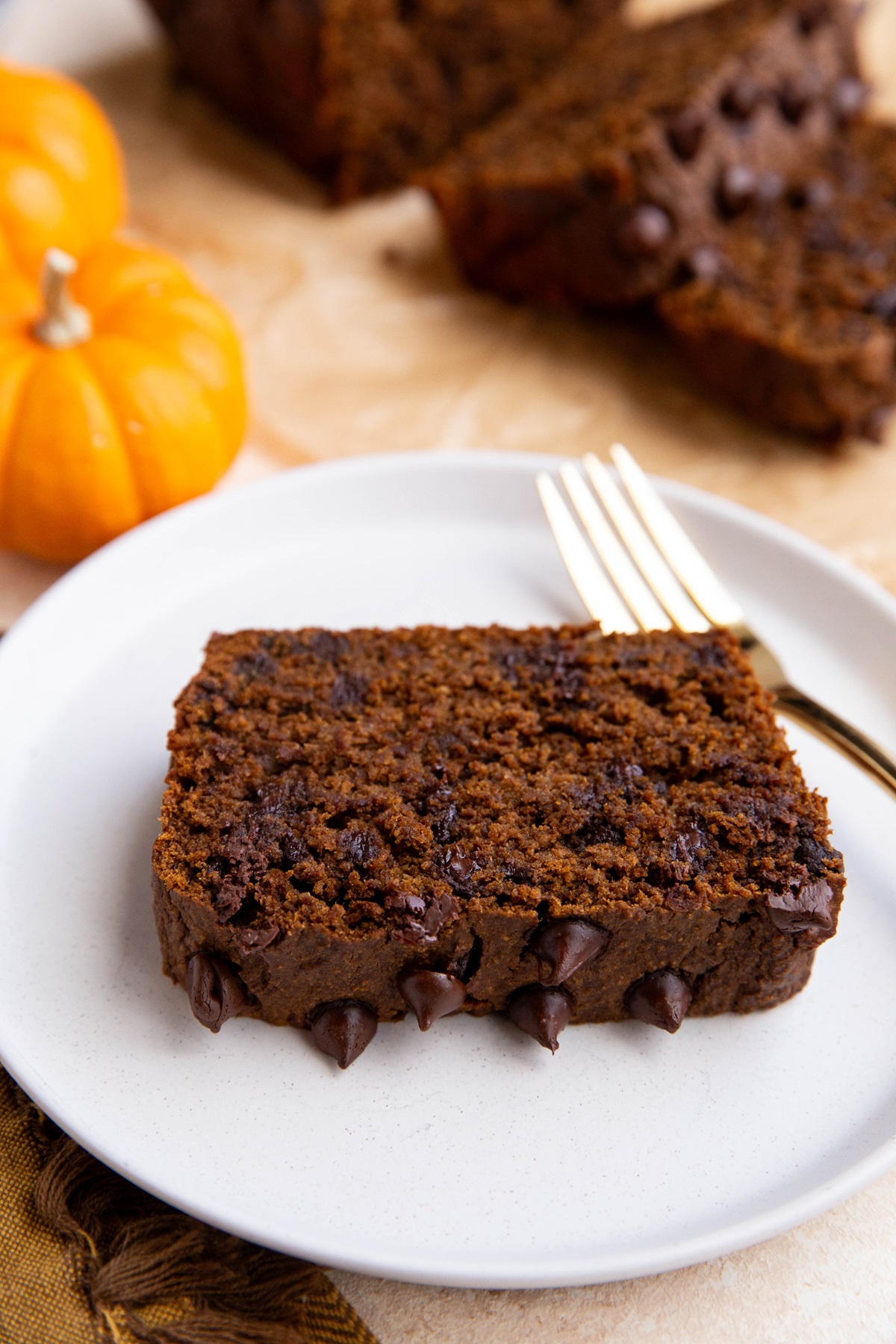 Slice of chocolate pumpkin bread on a plate with a fork.