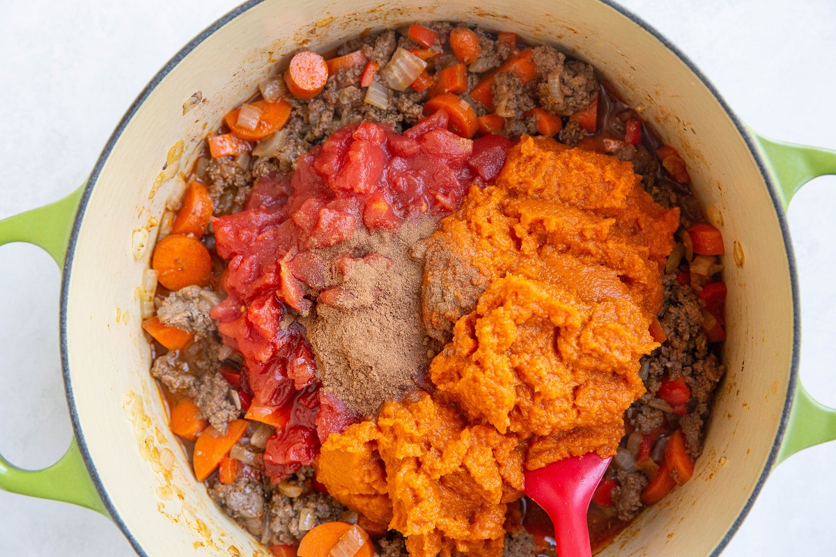 Beef, vegetables, pureed pumpkin, diced tomatoes, pumpkin spice and seasonings in a large pot to make chili.