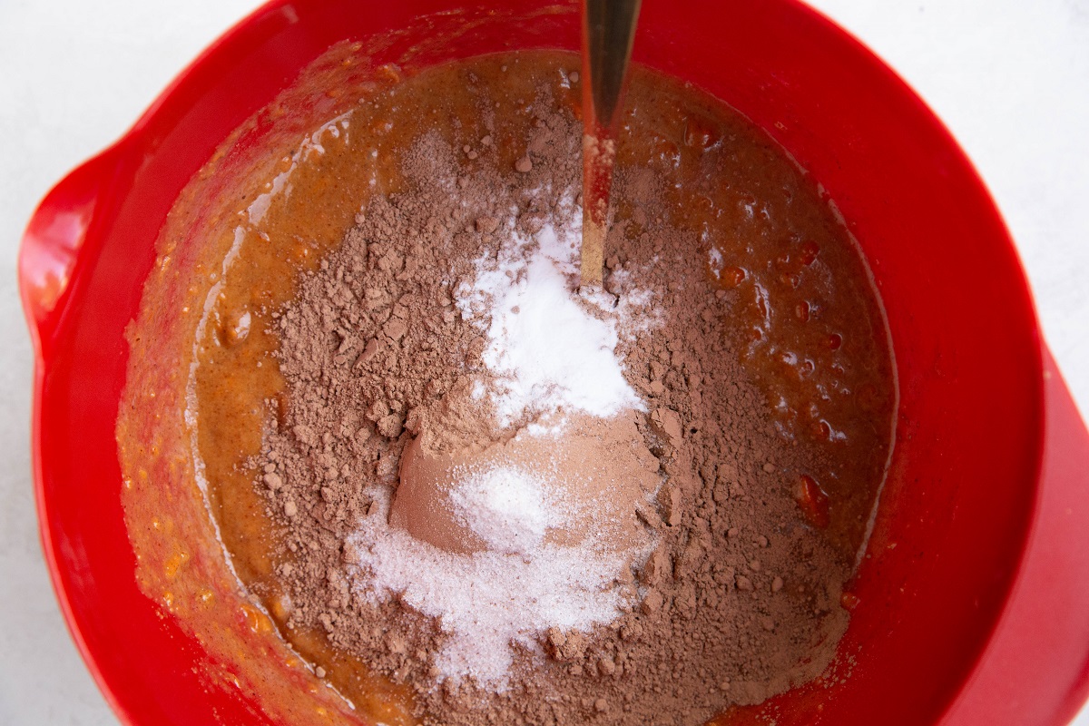 Wet ingredients and dry ingredients for sweet potato cake in a mixing bowl.