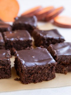 Individual slices of chocolate cake on a sheet of parchment paper.