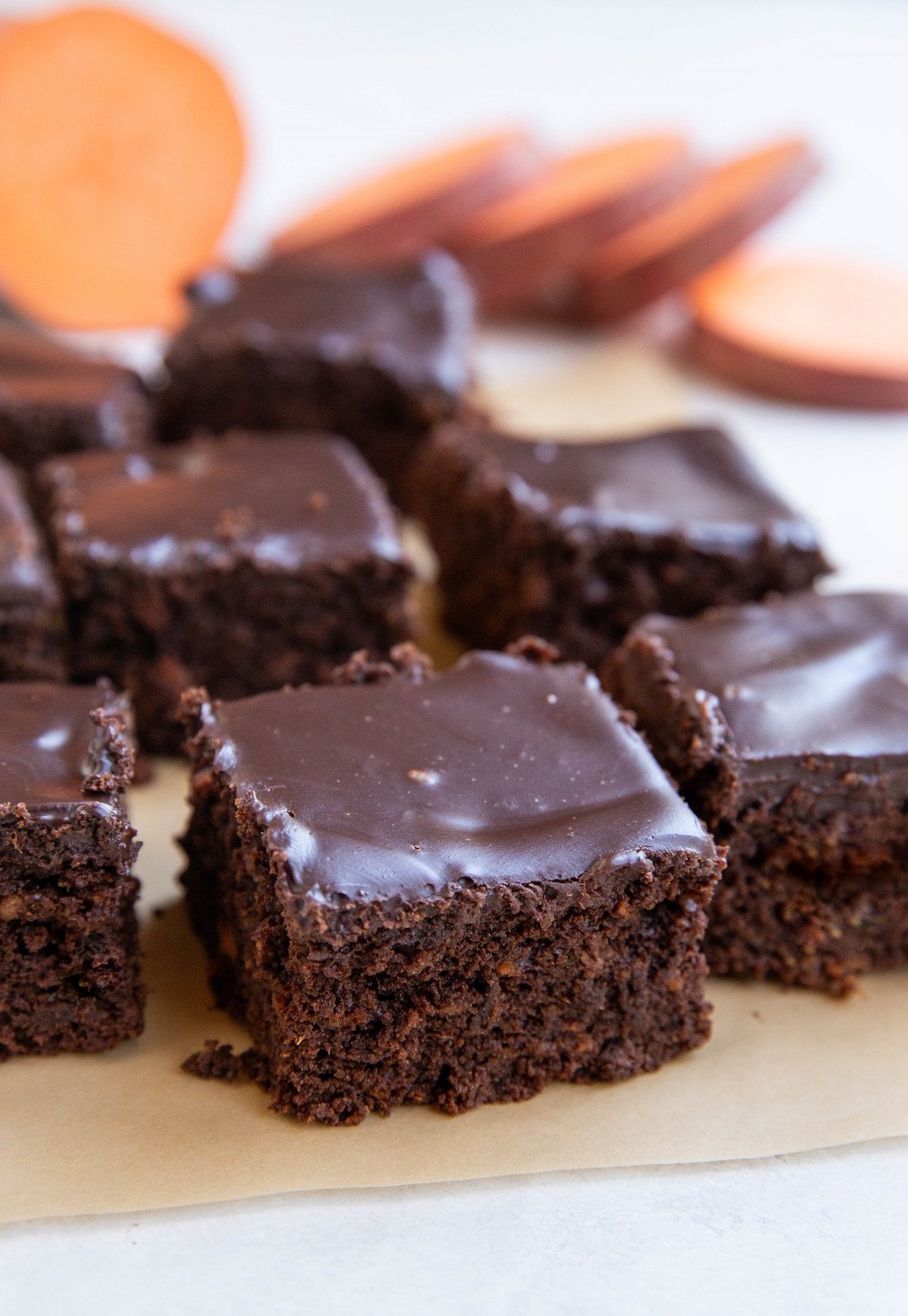 Individual slices of chocolate cake on a sheet of parchment paper.