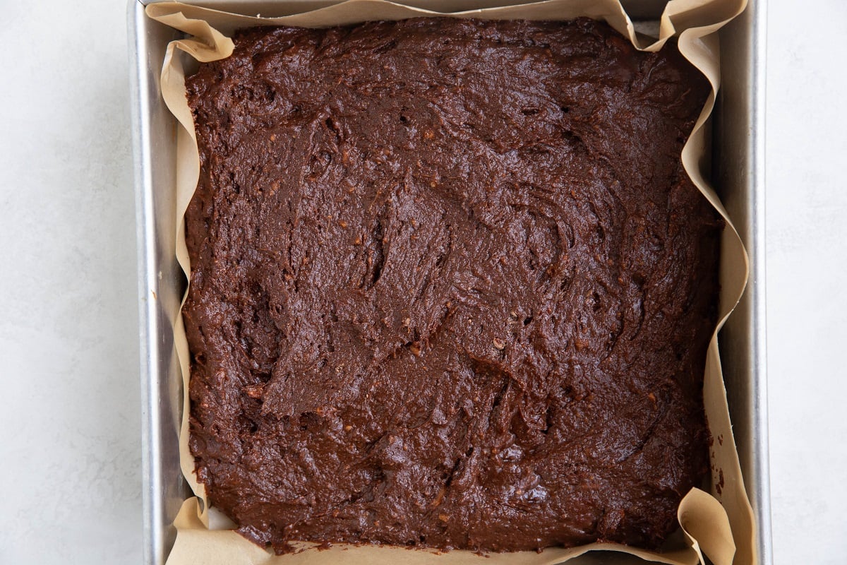 Chocolate cake batter in an 8-inch square cake pan, ready to bake.