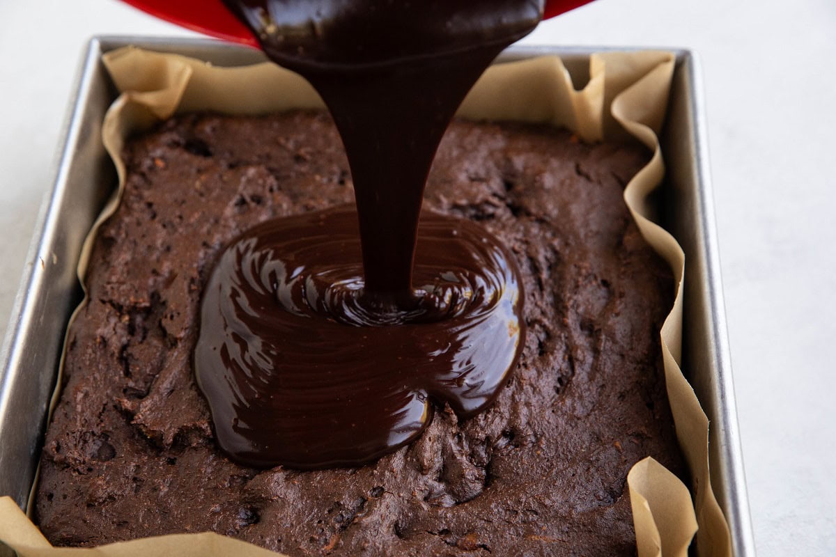 Pouring ganache over chocolate cake to use as chocolate frosting.