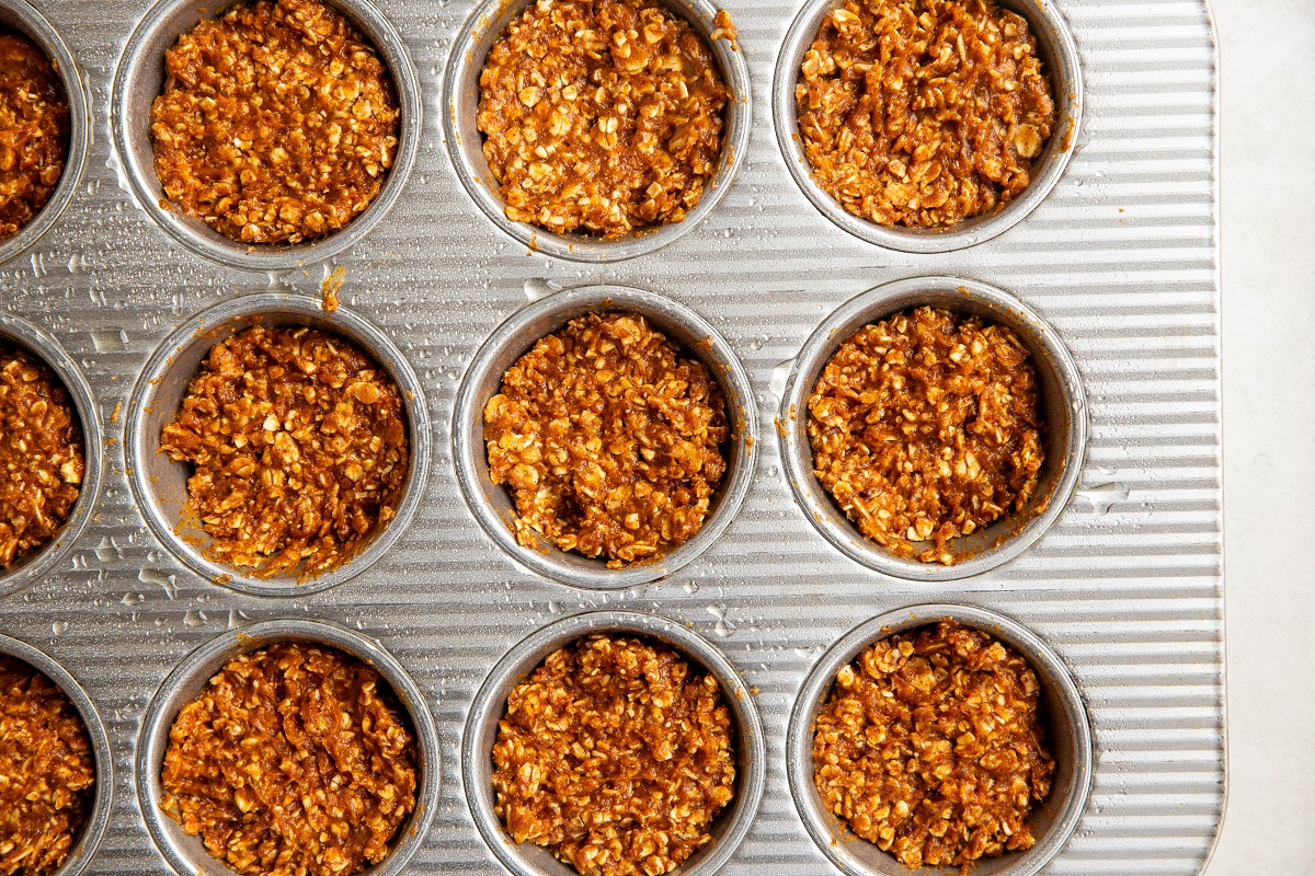 Muffin tray with oatmeal mixture pressed into the holes.