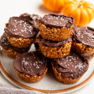 Plate of no-bake pumpkin cups with fresh pumpkins in the background.