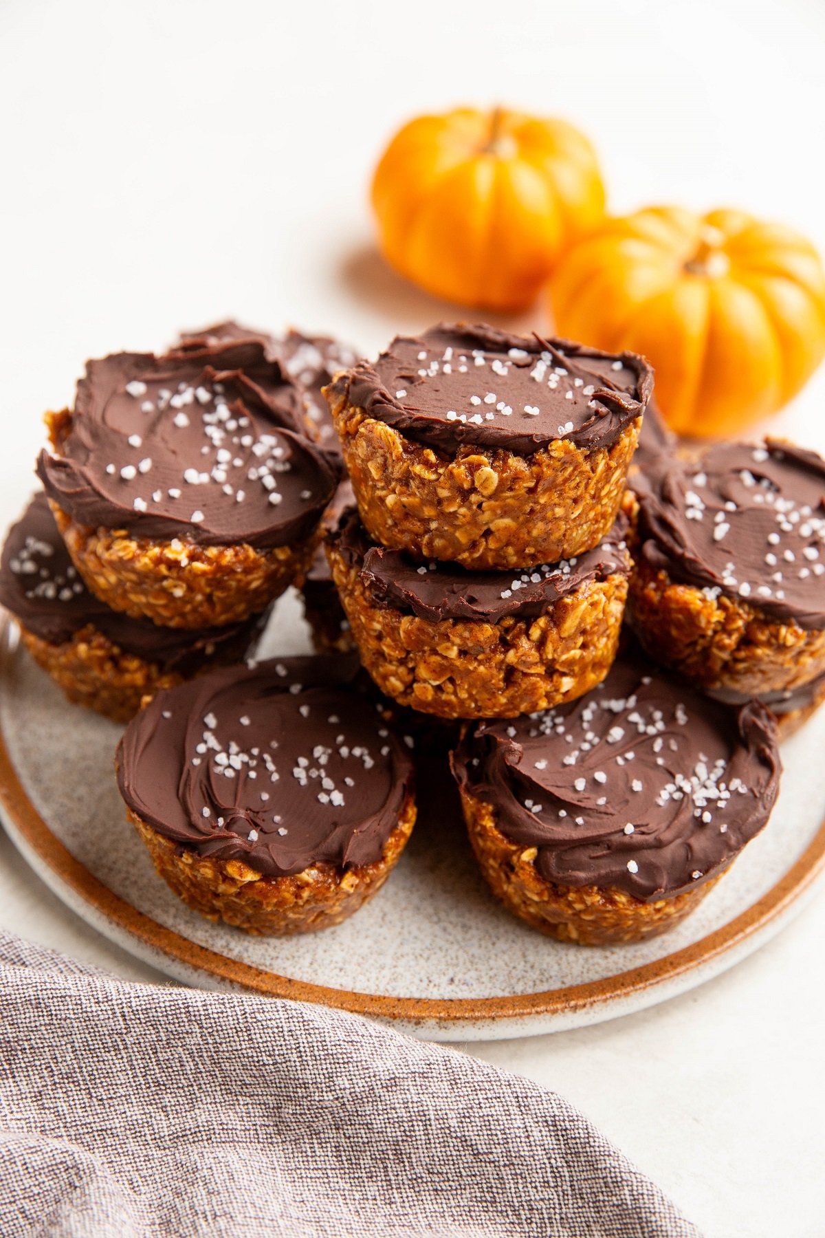 Plate of no-bake pumpkin cups with fresh pumpkins in the background.