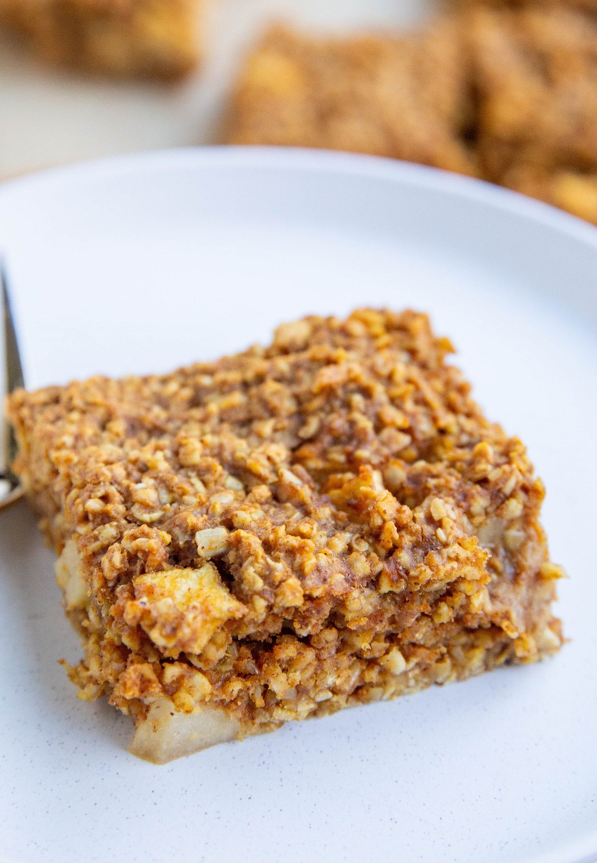 Slice of apple pumpkin oatmeal bar on a plate.