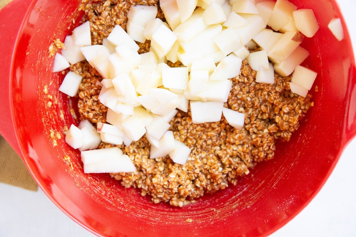 Chopped apple on top of pumpkin oat bar batter.