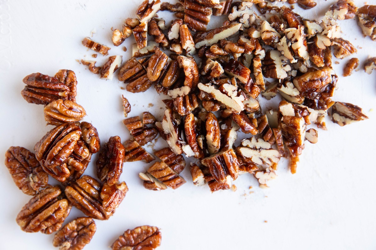 Cutting board with chopped candied pecans.