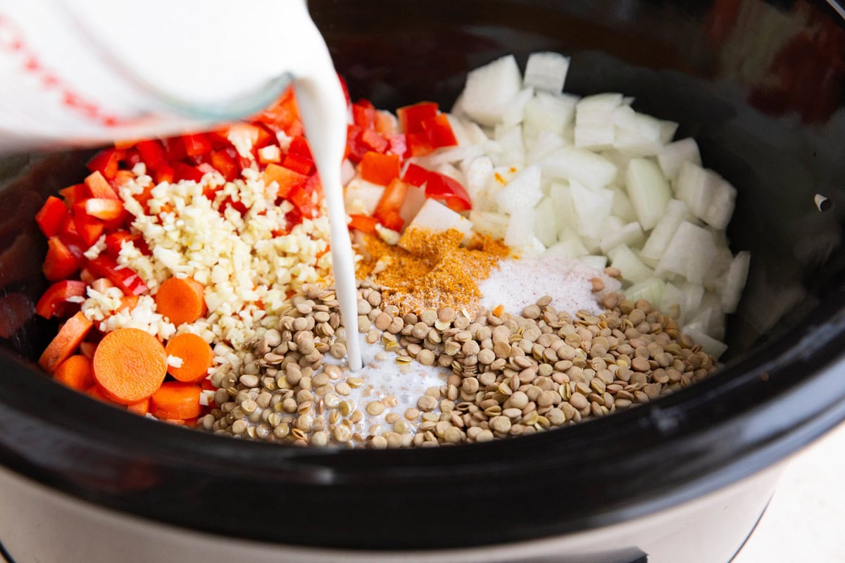 Pouring coconut milk into the crock pot.