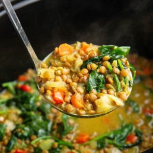 Ladle scooping out a scoop of curried lentil soup