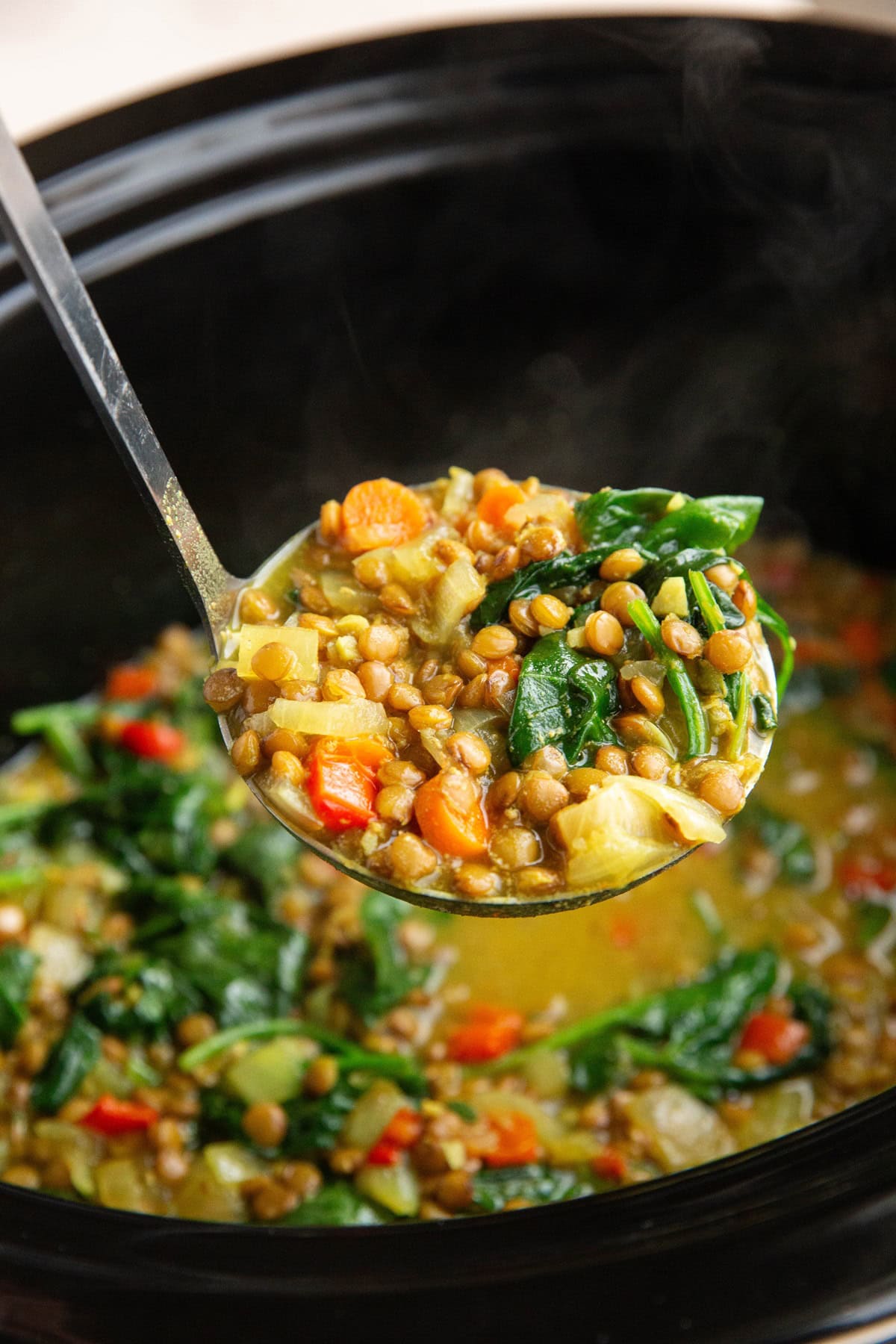 Ladle scooping out a scoop of curried lentil soup