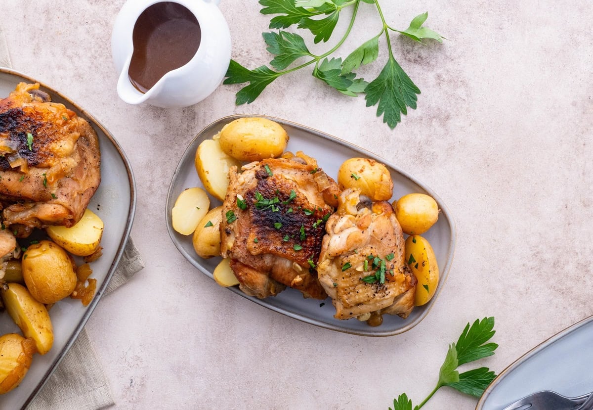 Plates of chicken and potatoes, ready to serve.