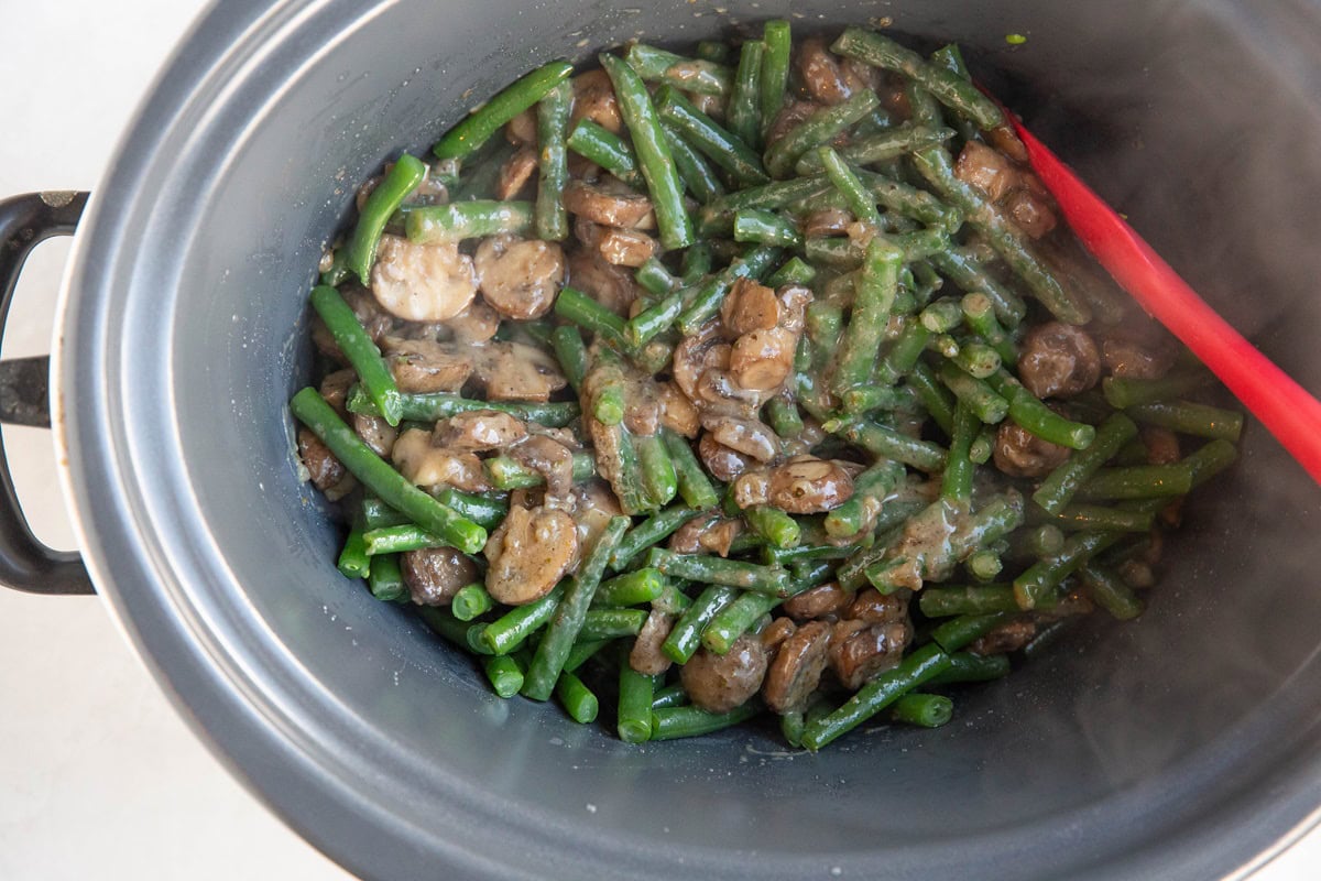 Green beans mixed with creamy mushroom sauce in a slow cooker.