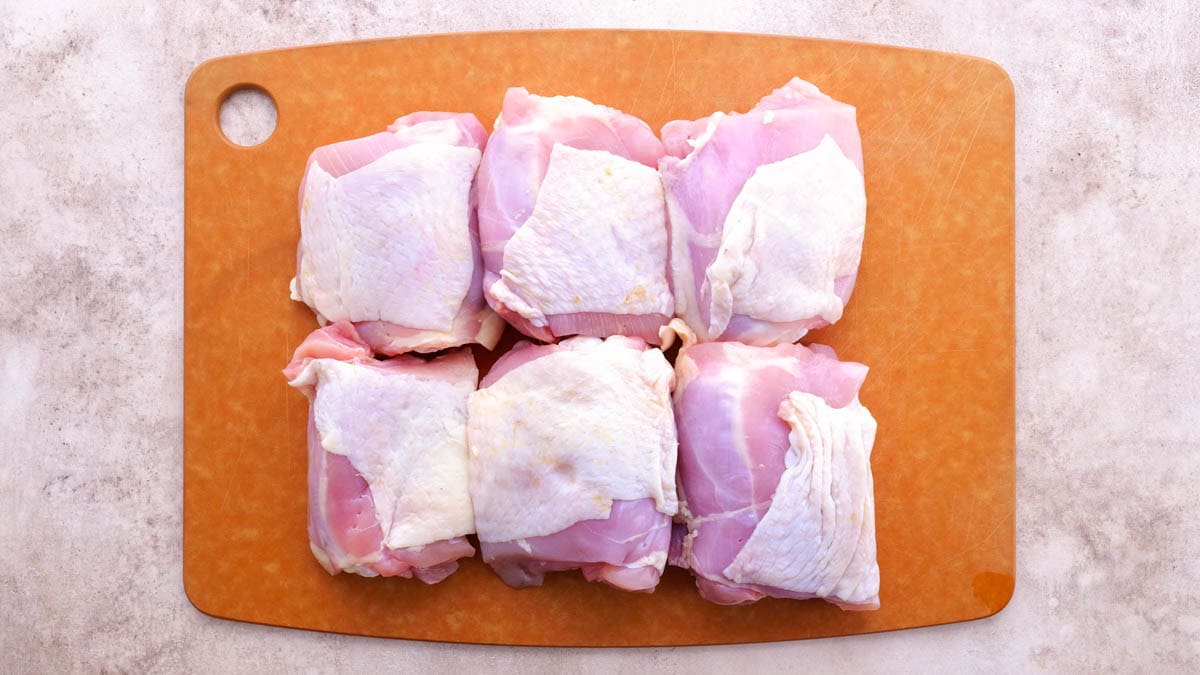 Chicken sitting on a cutting board.