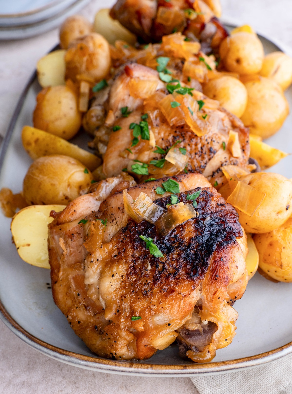 Platter of chicken thighs and potatoes, ready to serve.