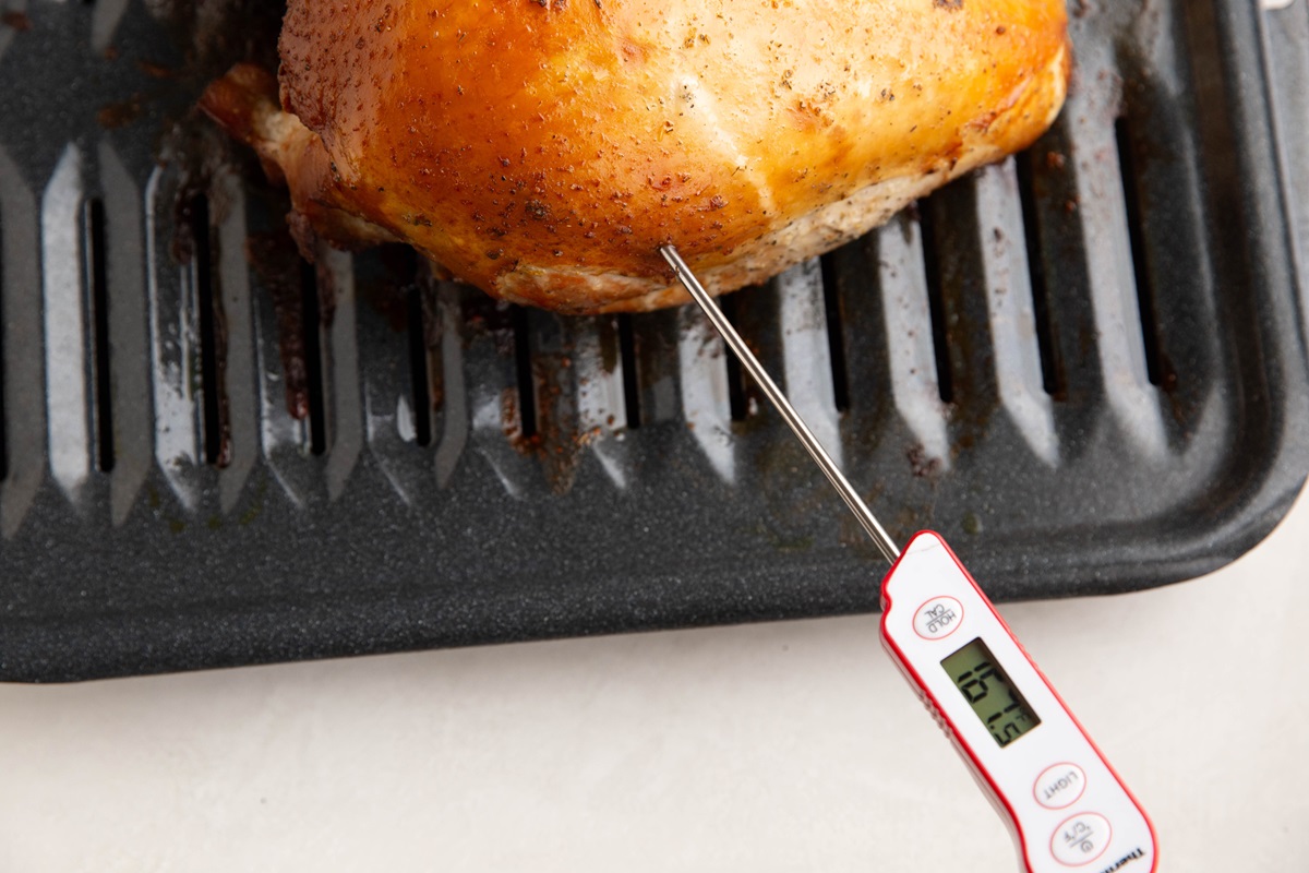 Thermometer poking out of a turkey breast.