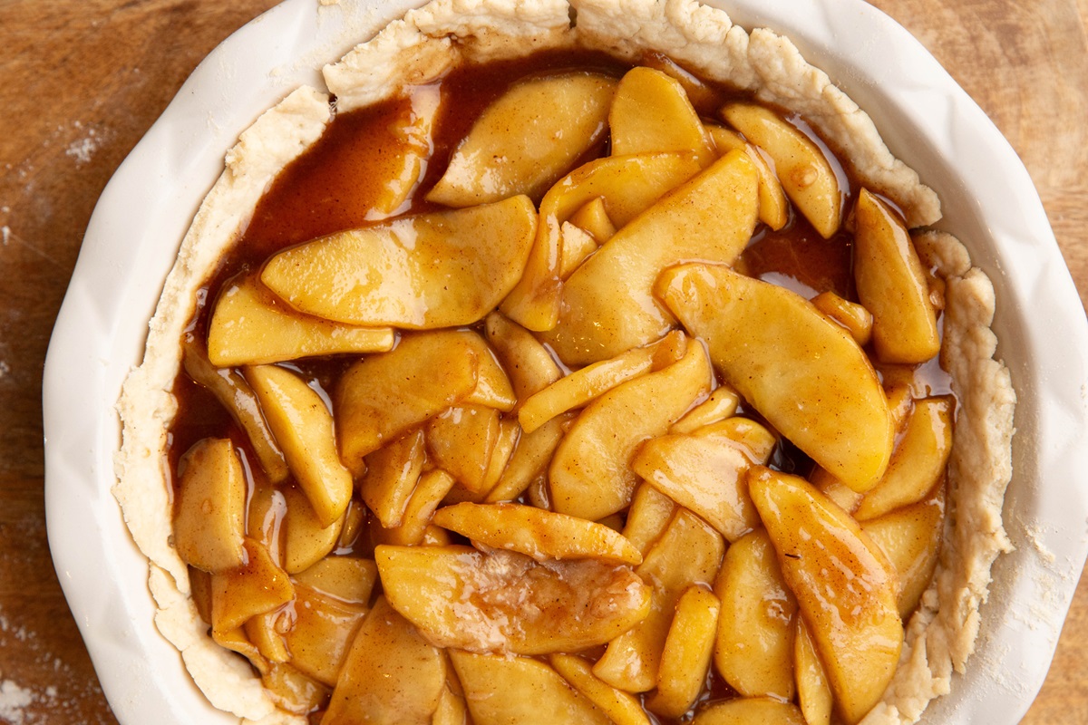Apple mixture in a prepared pie crust, ready to bake.