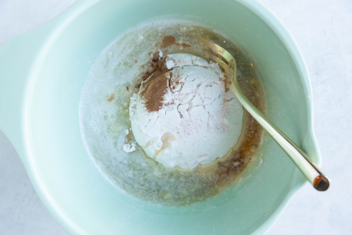 Ingredients for gluten-free crumble topping in a green mixing bowl, ready to be mixed together.