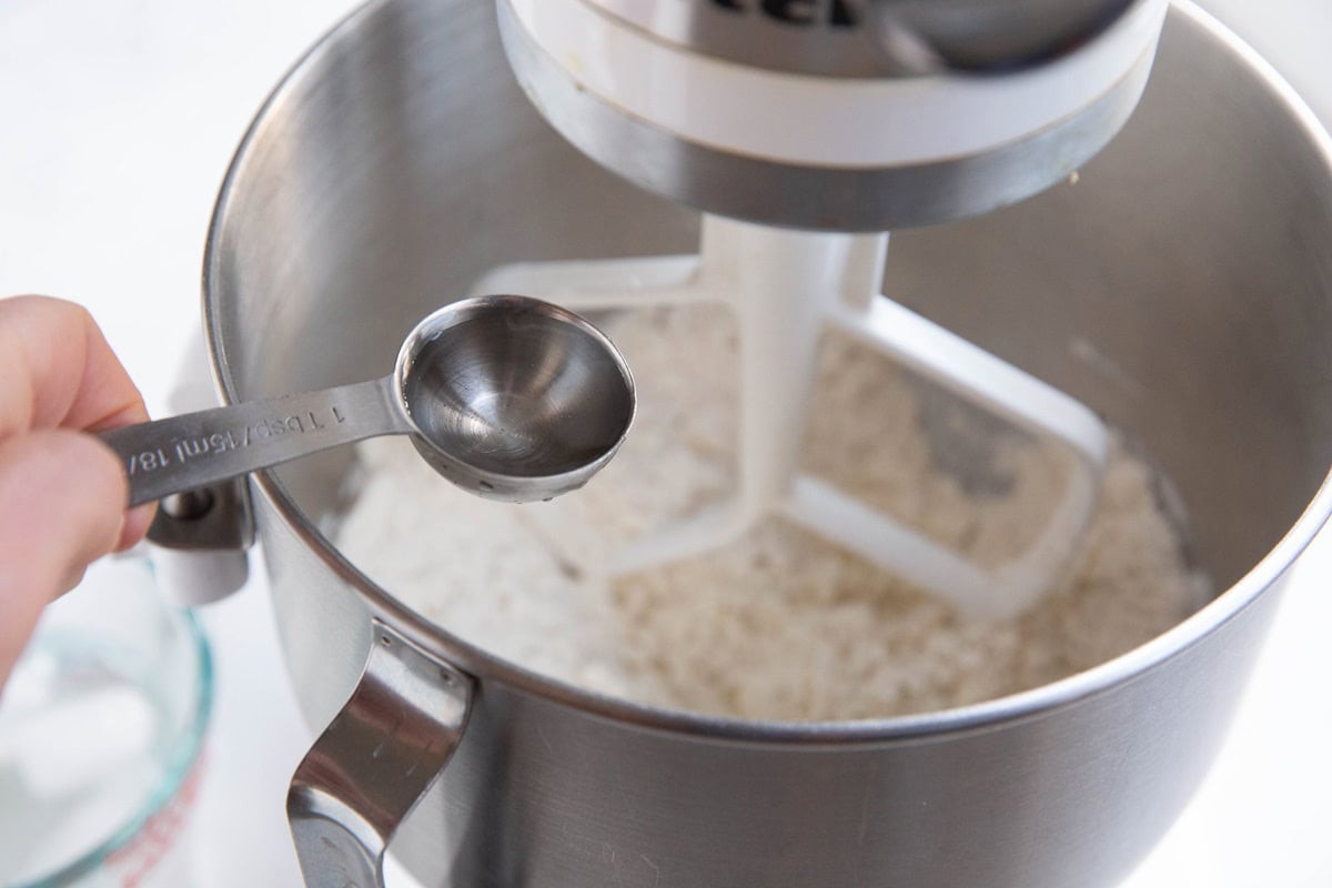 Pouring water into a stand mixer.