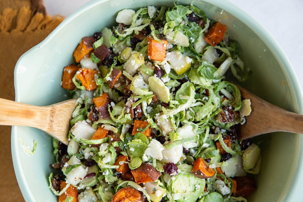 Brussels sprout salad mixed up in a mixing bowl.