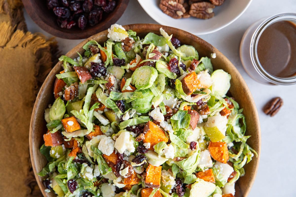 Wooden bowl of shredded brussel sprouts salad, ready to serve.