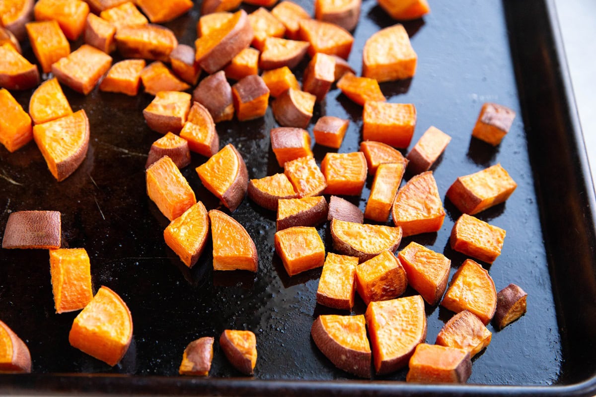 Chunks of roasted sweet potato on a baking sheet.