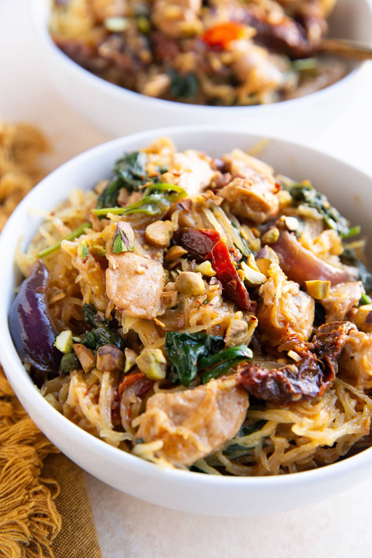 Spaghetti Squash with chicken and creamy sun-dried tomato sauce in two bowls, ready to eat.