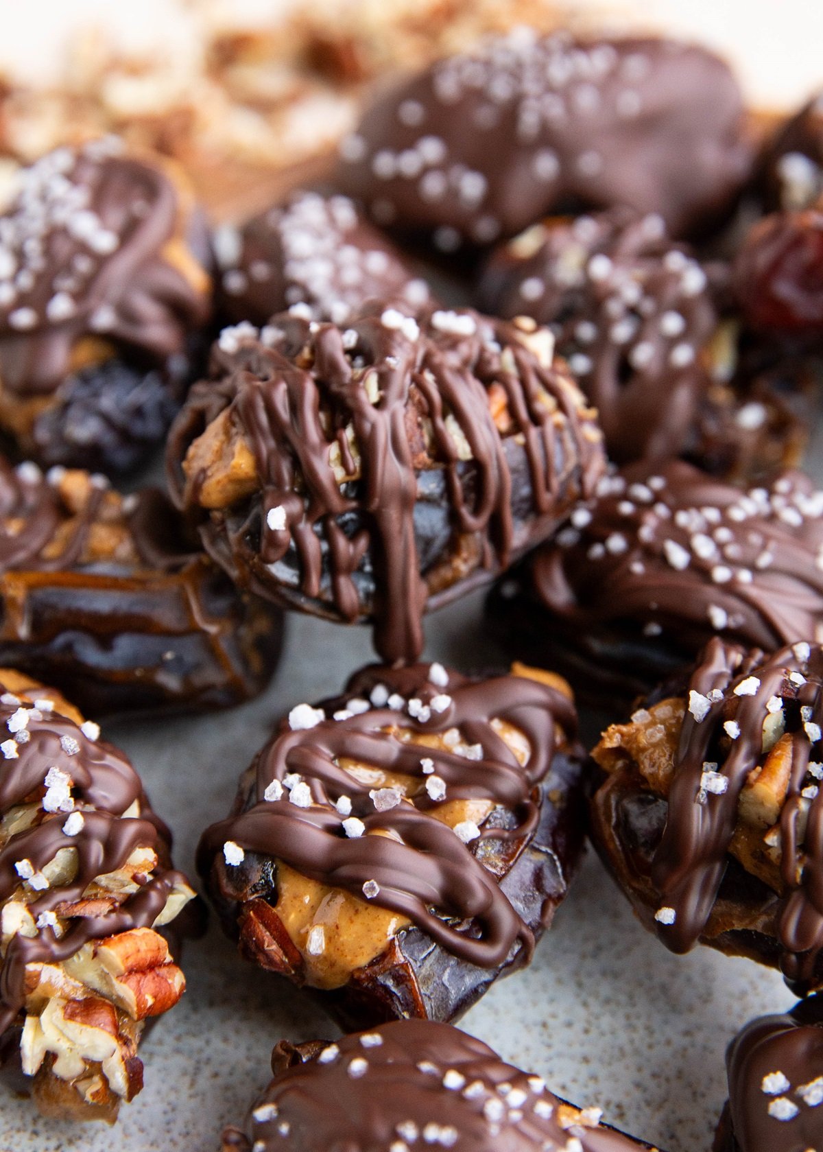Plate of stuffed dates drizzled with chocolate, ready to eat.