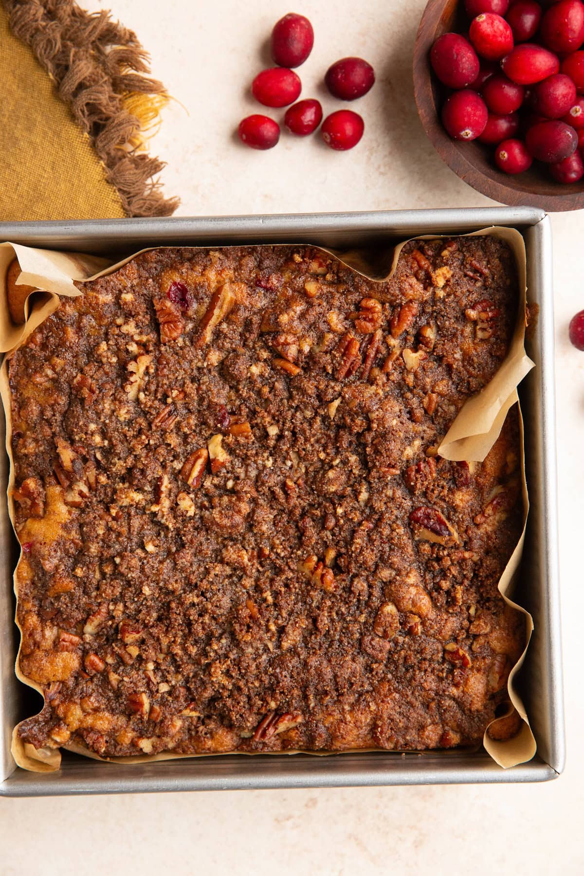 Square cake pan with cranberry orange coffee cake inside.