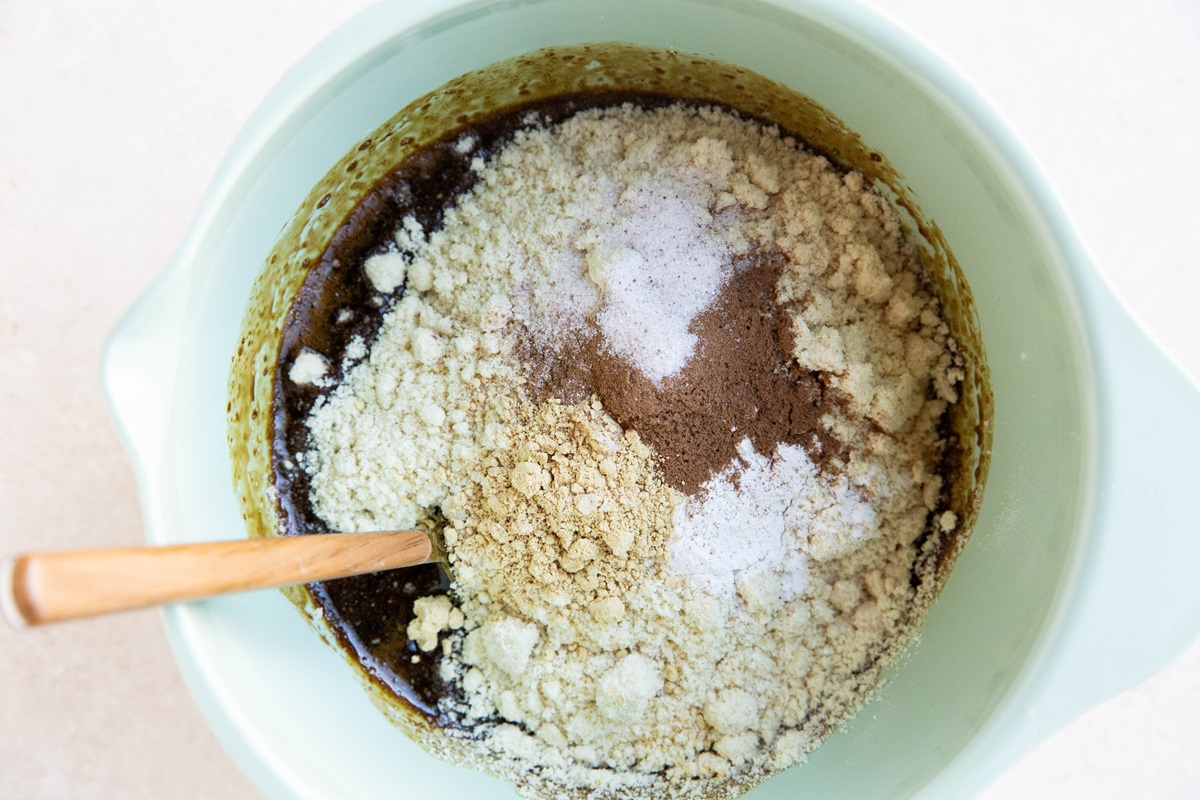 Mixing bowl with dry ingredients on top of wet ingredients, ready to be mixed together into a cake.