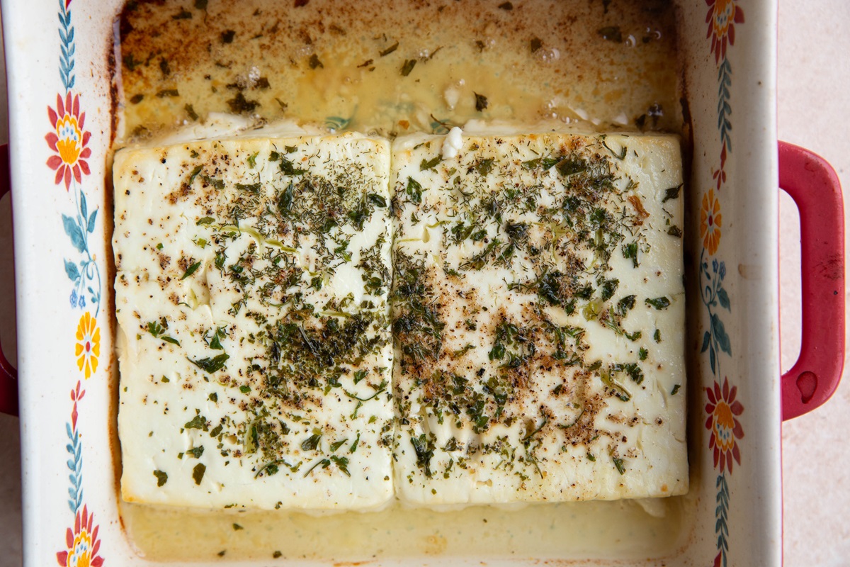 Baked feta cheese in a baking dish, fresh out of the oven.