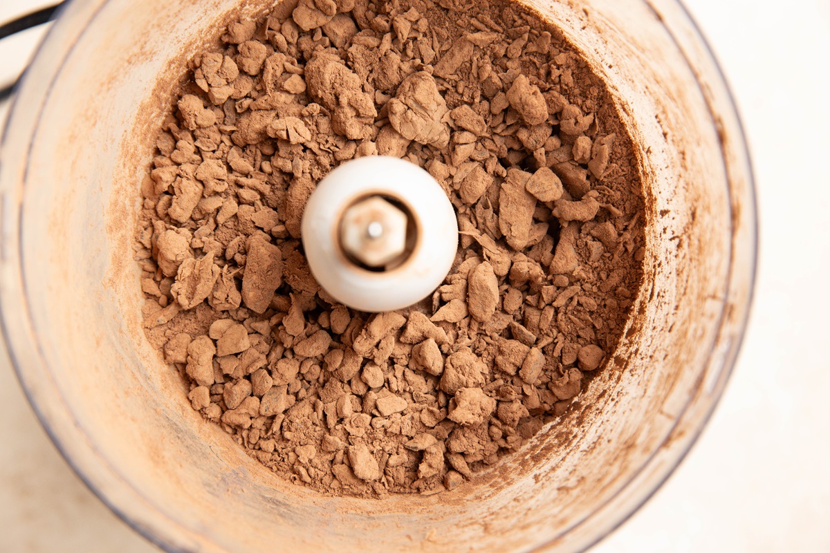 Chopped up dates and cocoa powder in a food processor before the coconut oil has been added.