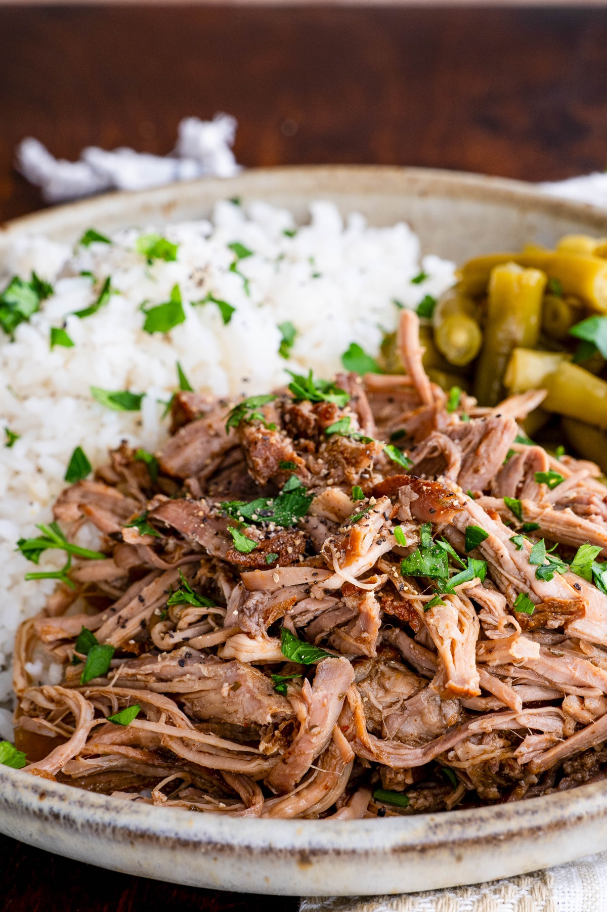 Close up of shredded pork in a bowl.