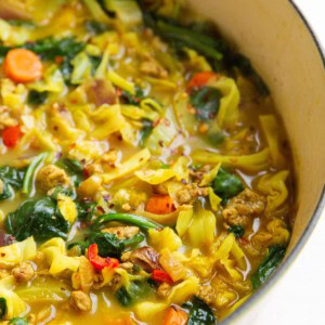 Ground turkey and cabbage soup with vegetables in a large pot.