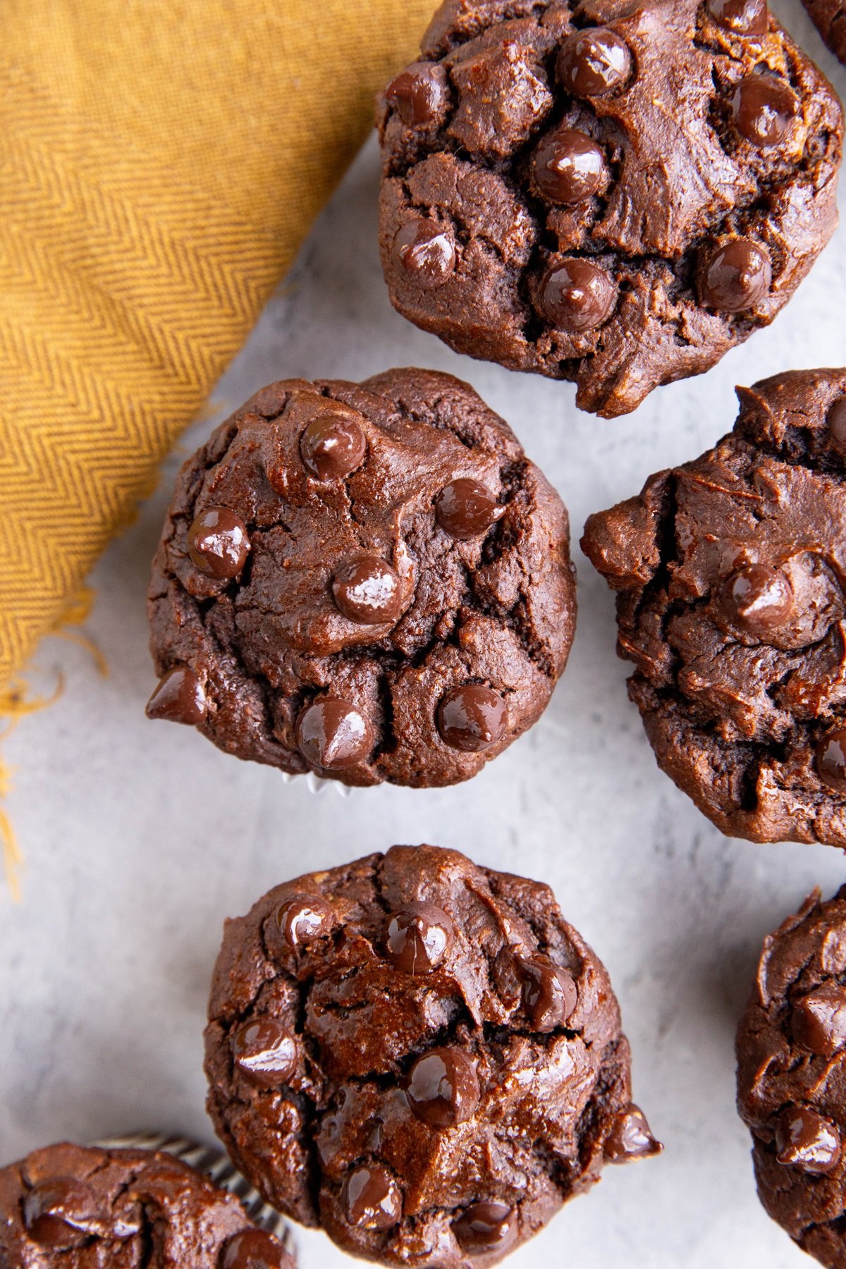 Double Chocolate sweet potato muffins sitting on a background, ready to eat.