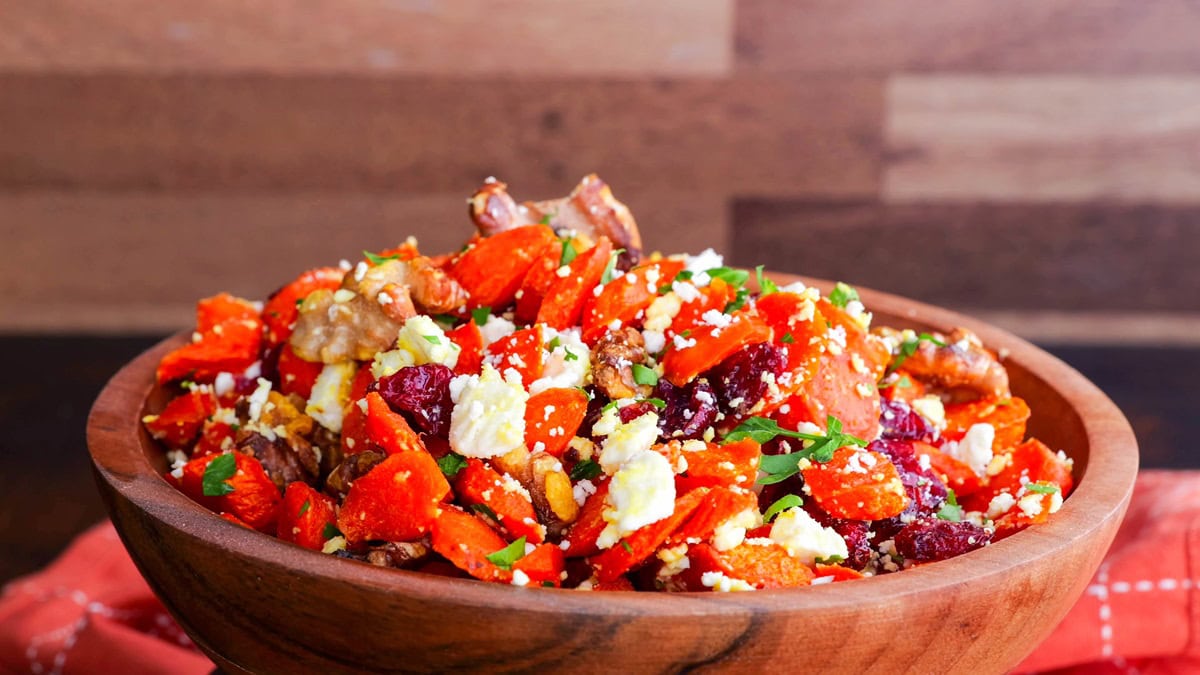 Wooden bowl of roasted carrots, ready to serve.