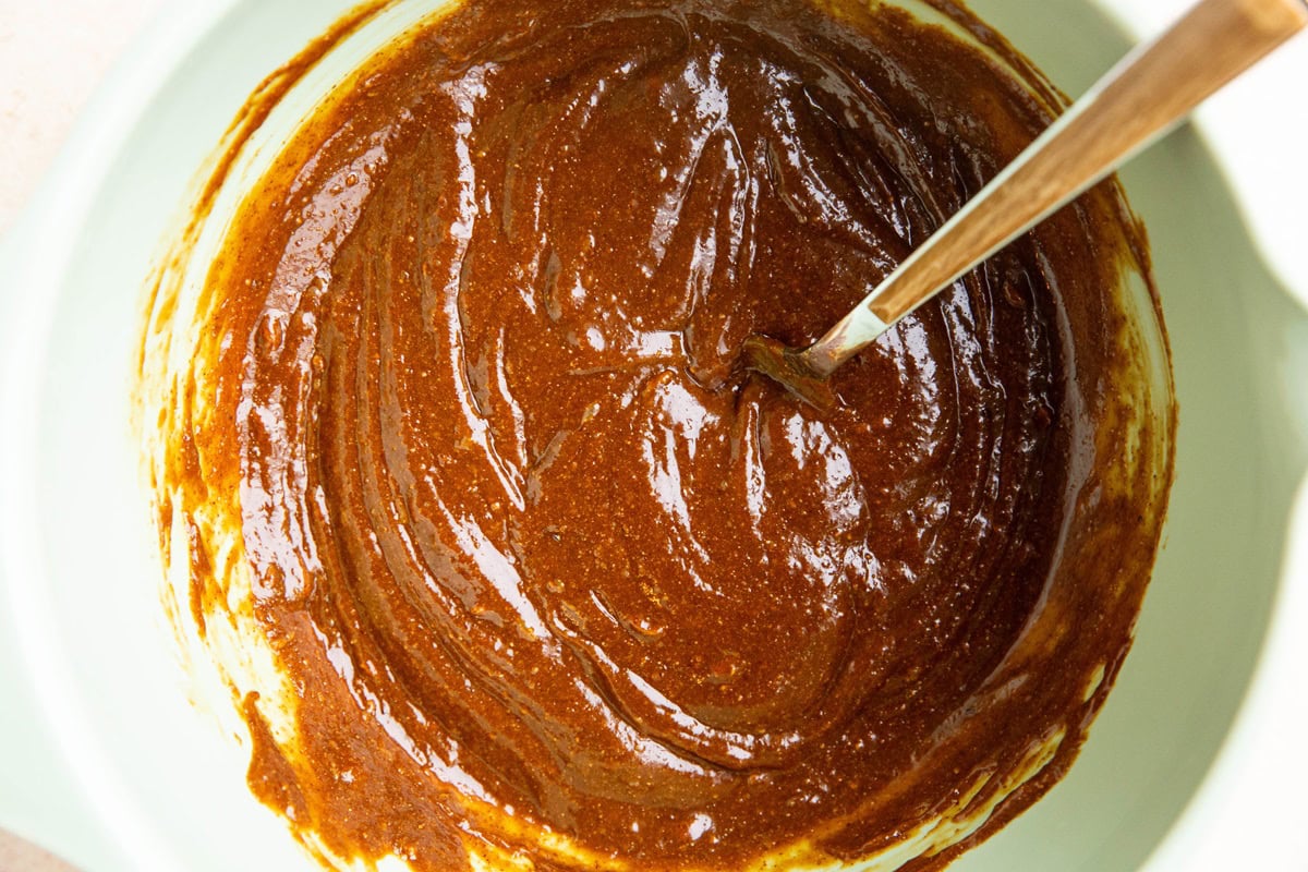 Wet ingredients for chewy ginger molasses cookies mixed up in a mixing bowl.