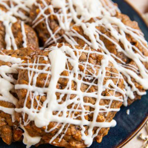 Ginger molasses cookies on a blue plate with gold stars and ornaments surrounding to signify Christmas time.