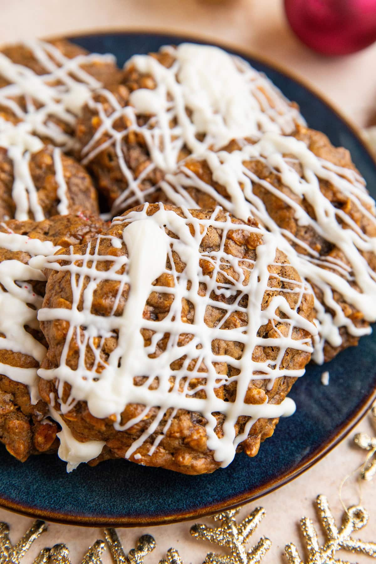 Ginger molasses cookies on a blue plate with gold stars and ornaments surrounding to signify Christmas time.