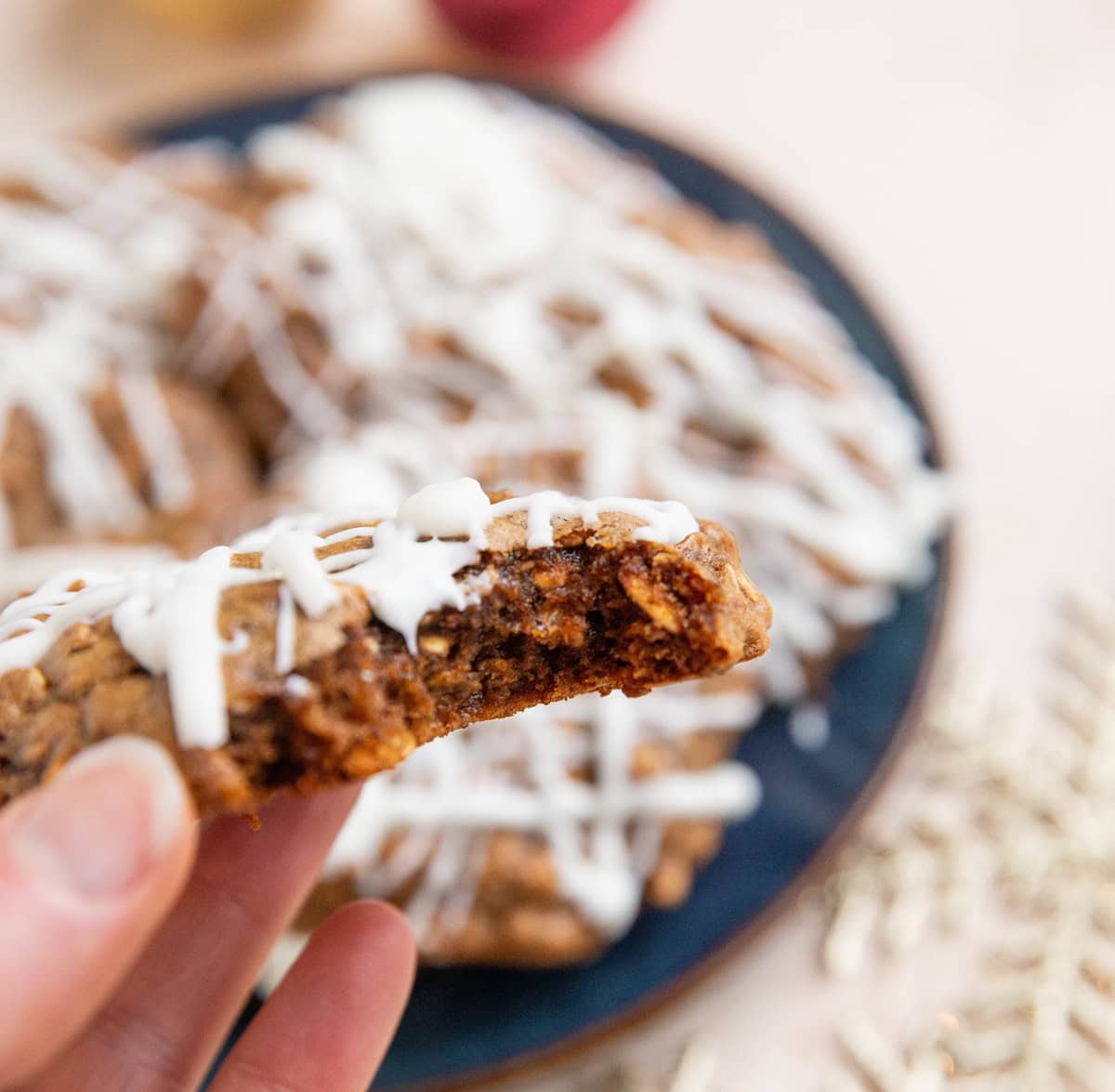 Hand holding a cookie with a bite takenout of it to expose the chewy inside.