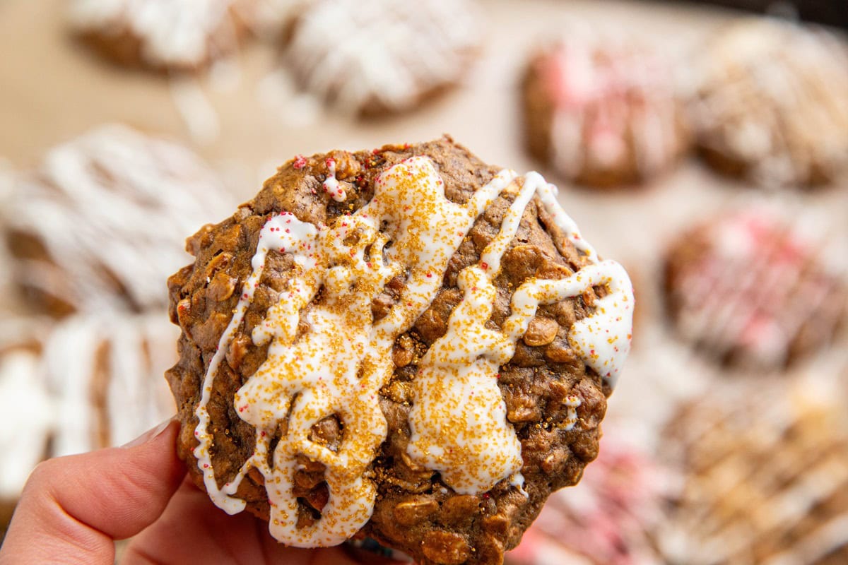 Oatmeal cookie drizzled with melted white chocolate and sprinkled with gold sprinkles.