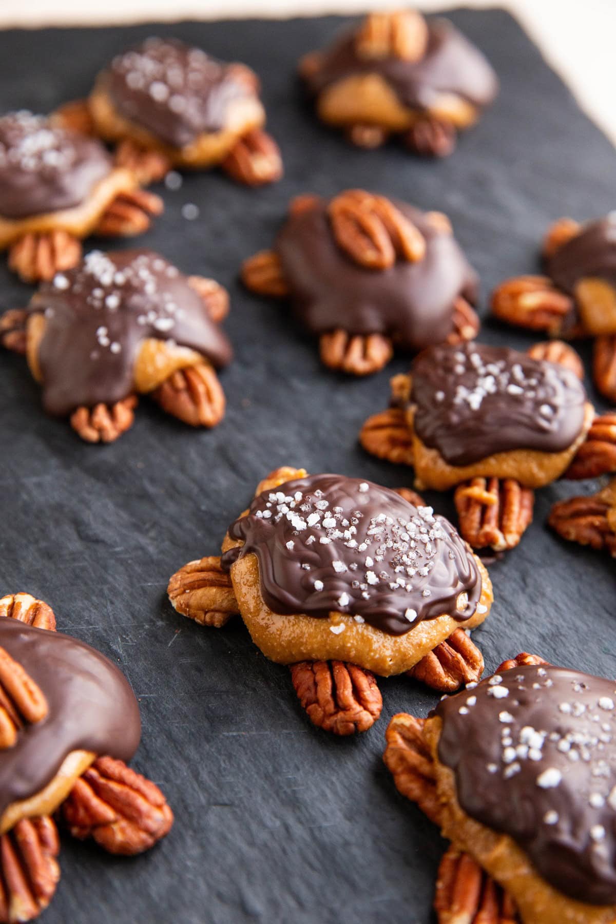 Pecan turtles on a black cutting board.