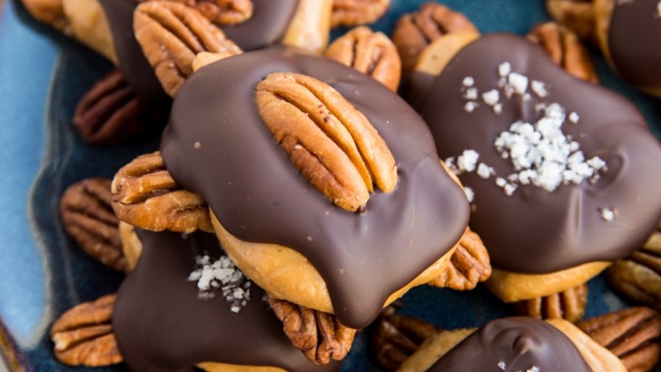 Pecan turtle candy on a blue plate, ready to serve